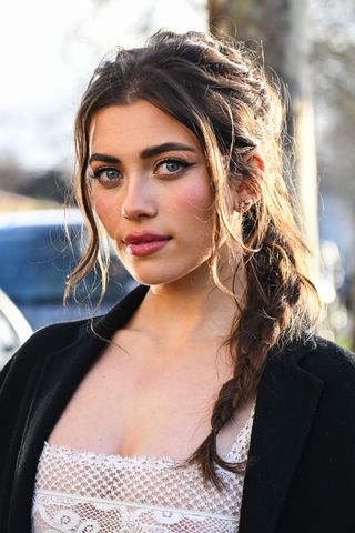 Brunette woman with loose plait with bangs GettyImages-1995698090