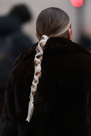 Brunette woman with long plait with lace GettyImages-2080588660