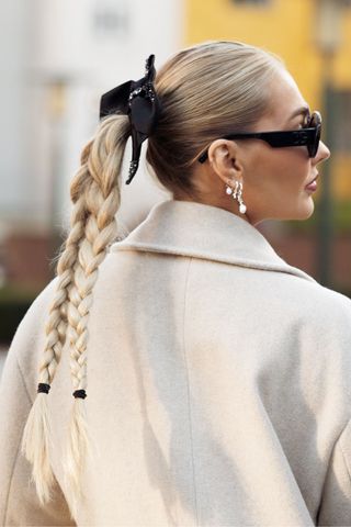 Blonde woman with double plaits and hair bow GettyImages-1976292727