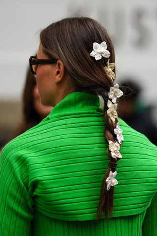 Brunette woman with plait with flowers in GettyImages-1606540718